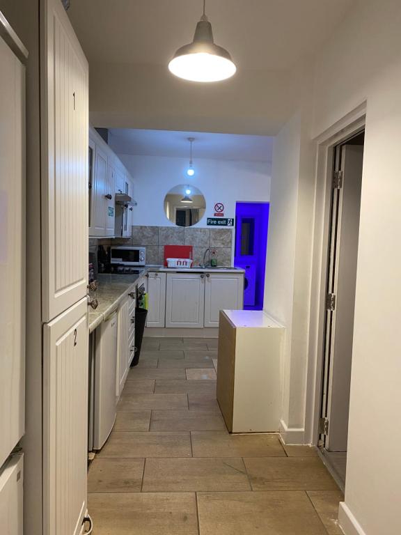 a kitchen with white cabinets and a tile floor at Calm residential house in Wyken