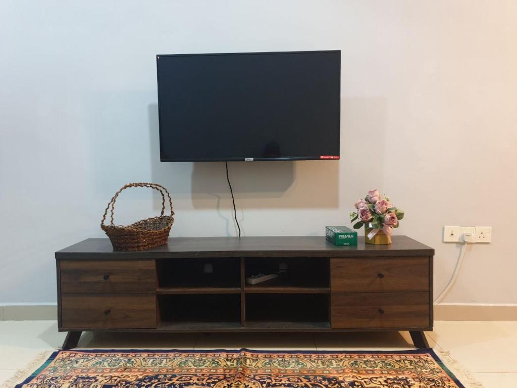 a entertainment center with a flat screen tv on a wall at Sarod Inn Meru Homestay 3-bedroom Apartment in Klang