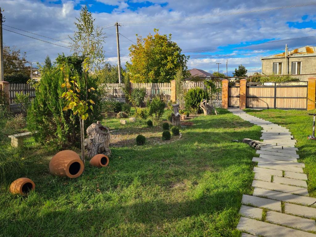 un jardín con un sendero y una valla en Savanna Guest House, en Dedoplis Tskaro