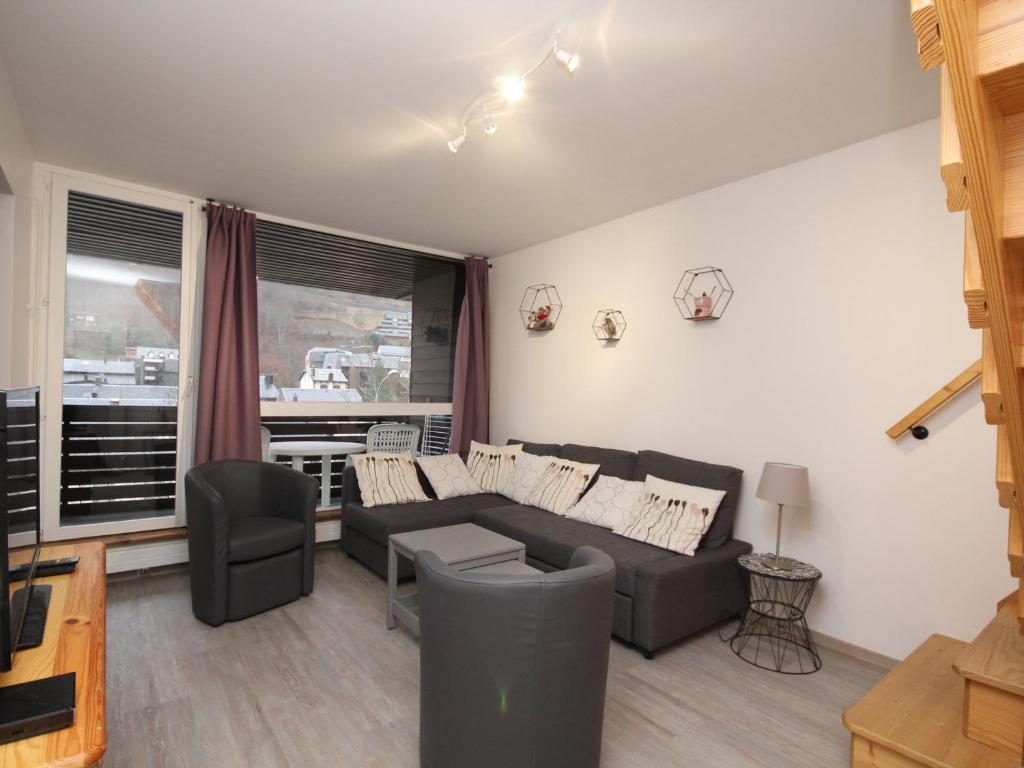 un salon avec un canapé et une chaise dans l'établissement Mont-Dore : Duplex 4P avec Balcon, Garage et Wi-Fi - FR-1-608-3, à Le Mont-Dore