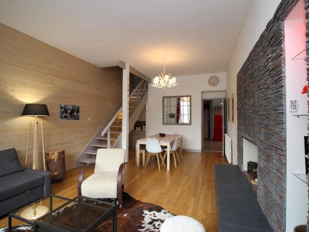 a living room with a staircase and a dining room at Appartement Mont-Dore, 3 pièces, 8 personnes - FR-1-608-1 in Le Mont-Dore