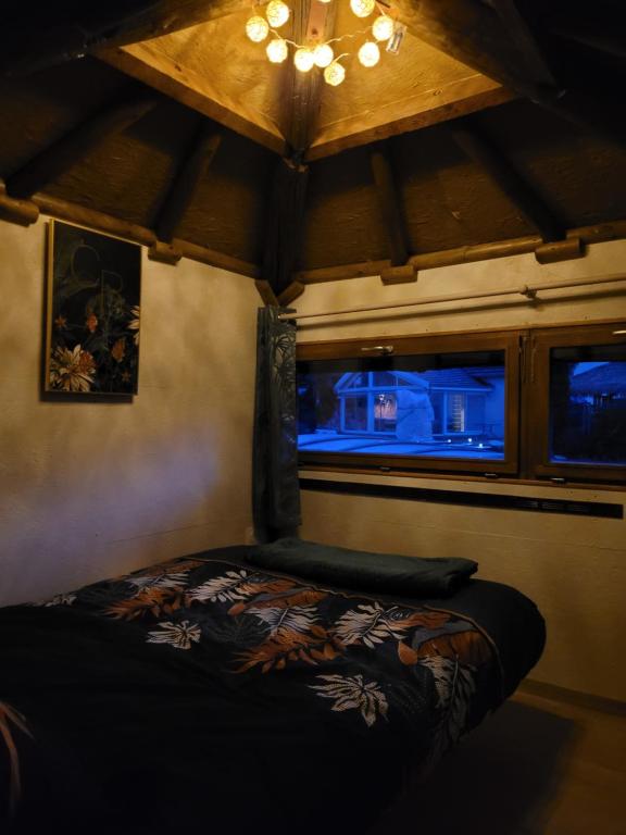 a bedroom with a bed and a window in a room at La paillote idyllique in Faverolles-sur-Cher