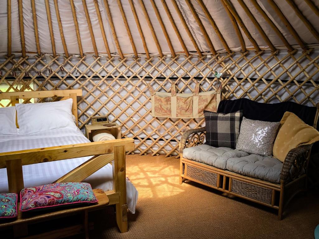 pokój z łóżkiem i kanapą w jurcie w obiekcie 'Villager' the Yurt at Pentref Luxury Camping w mieście Penuwch