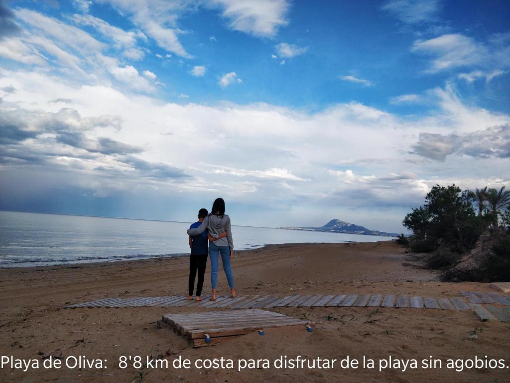 オリーバにあるHELLO OLIVA BEACH Anaの海を見下ろす海岸に立つ二人