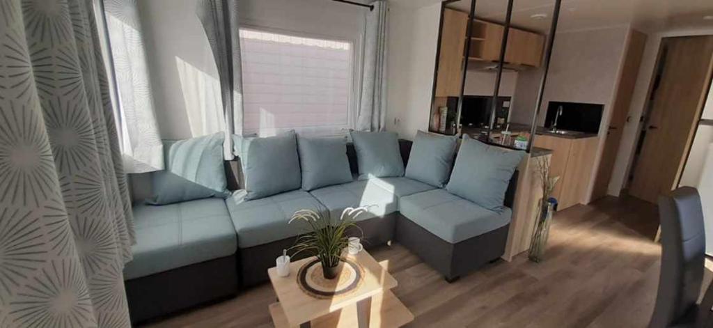 a living room with a blue couch in front of a window at Le lac des rêves à Lattes in Lattes