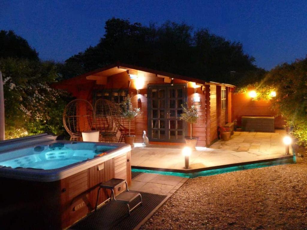 a hot tub in a backyard at night at Easthorpe Retreat in Colchester