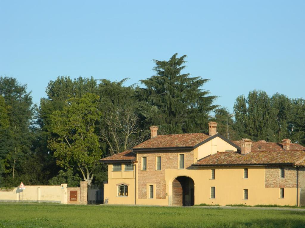 una casa vieja con un arco en un campo en Agriturismo Cascina Pezzolo, en Lodi