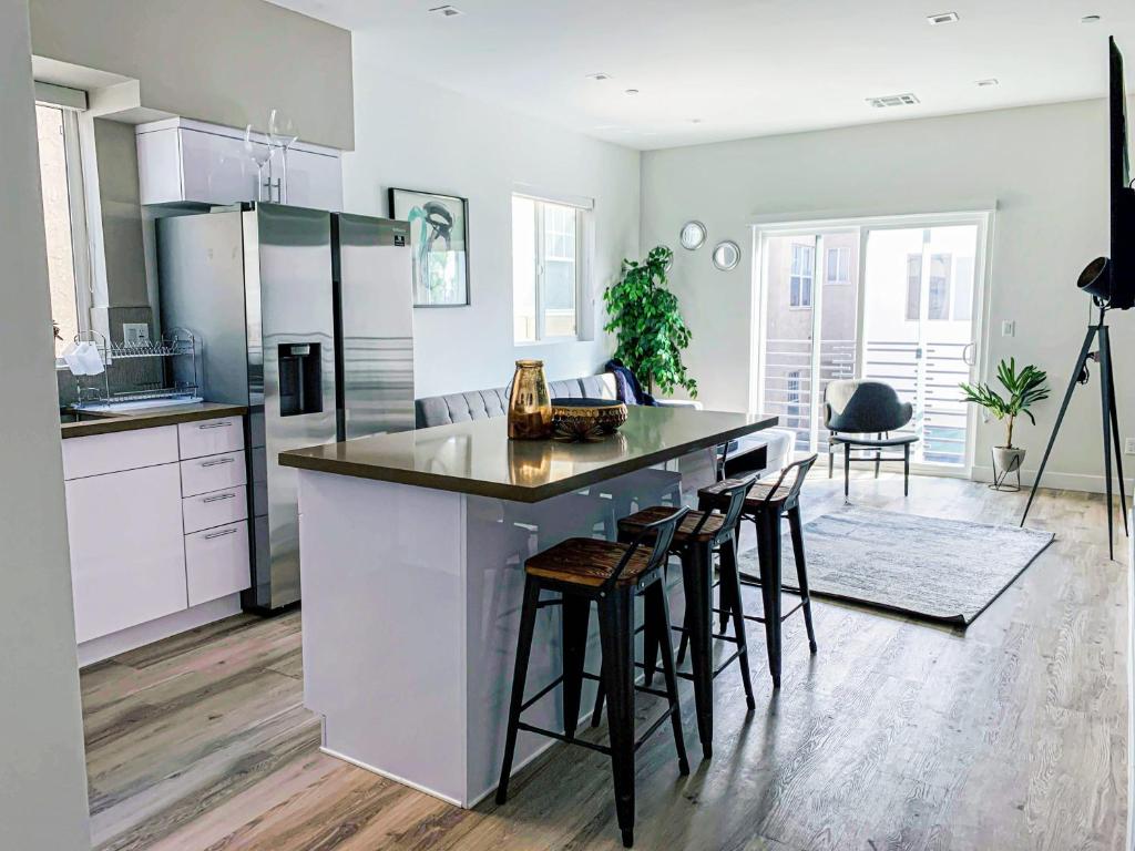 a kitchen with a counter and some stools in it at Spacious Townhouse in Mid City - CR4-WIN in Los Angeles