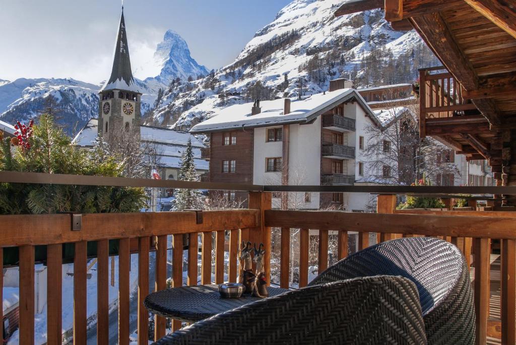 a table on a balcony with a view of a mountain at Matterhorn Lodge Boutique Hotel & Apartments in Zermatt