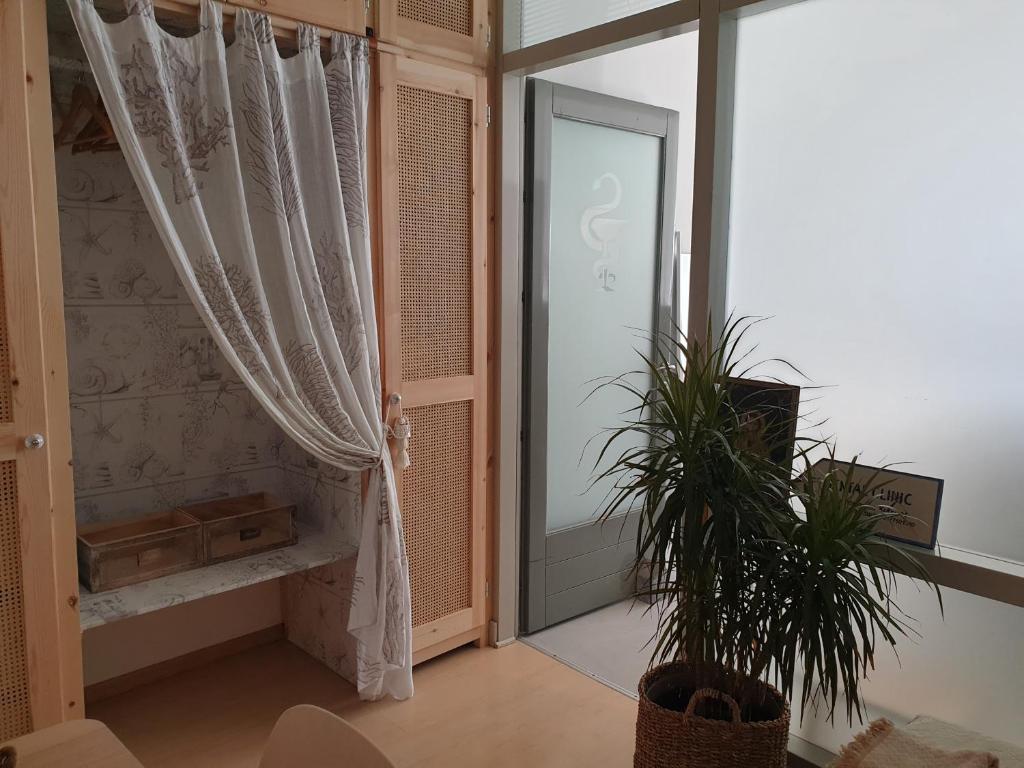 a room with a window and a door with a plant at Aretousa Deluxe Downtown Apartment in Skala
