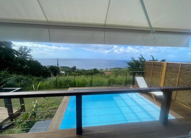a swimming pool with a view of the ocean at Le Jardin Zen in Bouillante