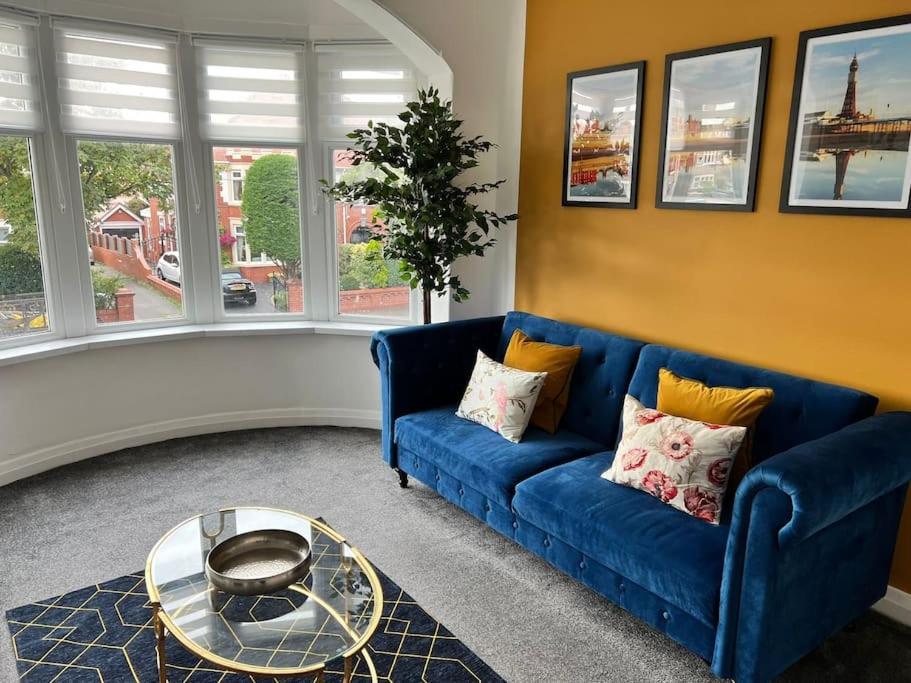 a living room with a blue couch and a table at Hidden Gem w/ parking Short walk to Pleasure Beach in Blackpool
