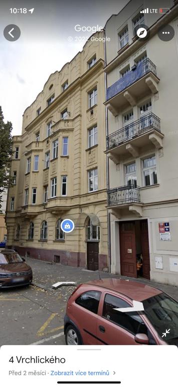czerwony samochód zaparkowany przed budynkiem w obiekcie Central studio - Anděl w Pradze