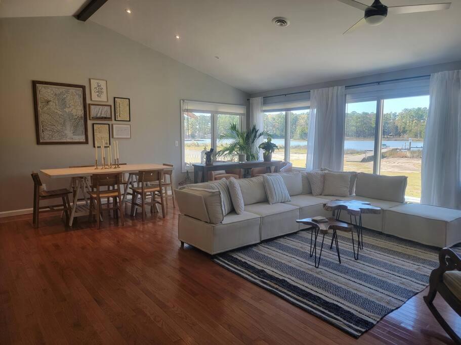 een woonkamer met een witte bank en een tafel bij 3 Bedroom Bay Home with Private Dock & all the Amenities in Onemo