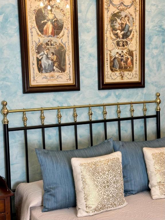 a bedroom with paintings on the wall and a bed with pillows at Hotel Boutique Casa Veracruz in Estepona