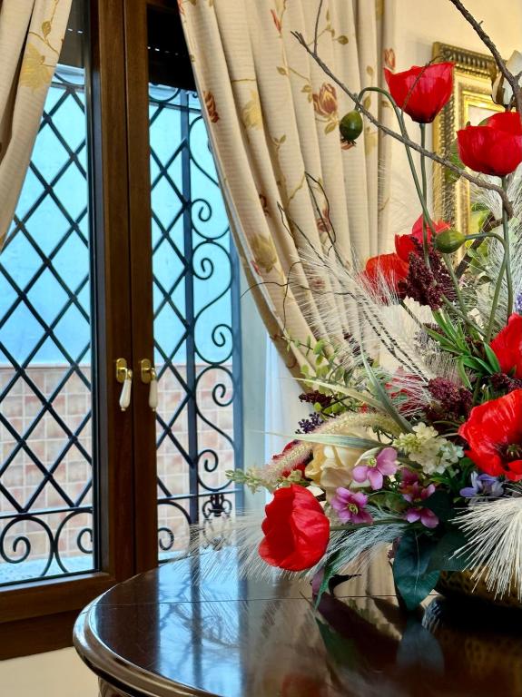 a vase of red roses sitting on a table at Hotel Boutique Casa Veracruz in Estepona