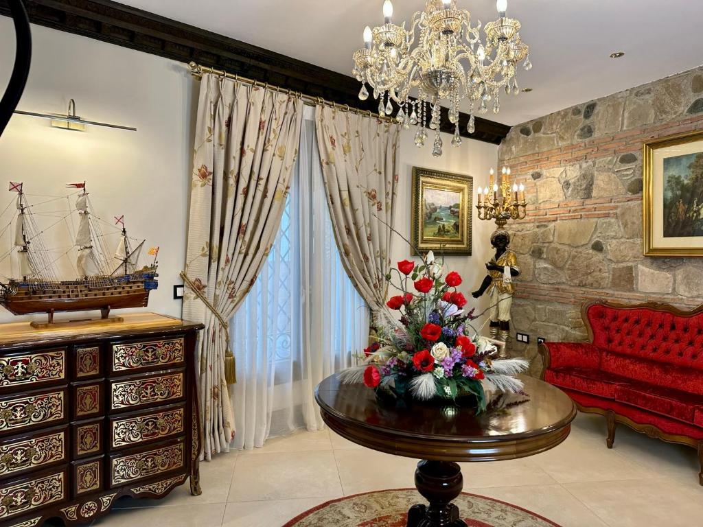 a living room with a red couch and a table with flowers at Hotel Boutique Casa Veracruz in Estepona