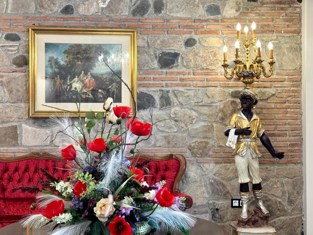 a statue of a boy and flowers in a room at Hotel Boutique Casa Veracruz in Estepona