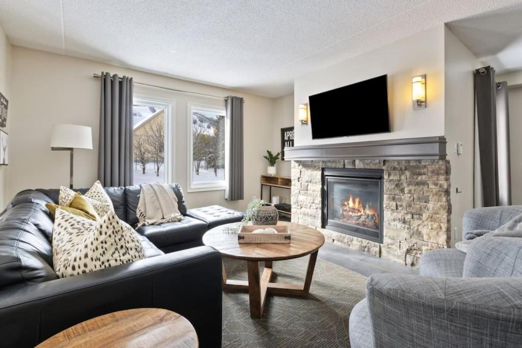 a living room with a couch and a fireplace at Blue Mountain Chalet Condo with Amazing Location in Blue Mountains