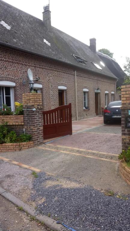 a brick house with a car parked in front of it at Studio Marcel Proust in Crasville-la-Mallet