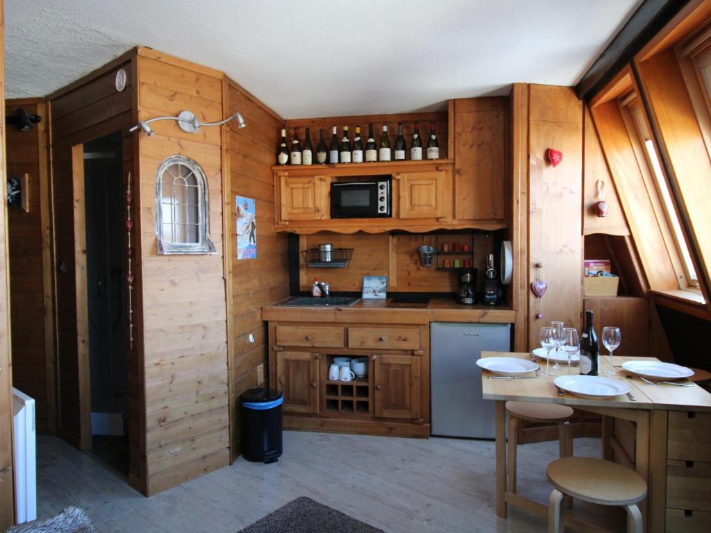 una cocina con armarios de madera y una mesa con sillas. en Studio Avoriaz, 1 pièce, 4 personnes - FR-1-633-27, en Avoriaz