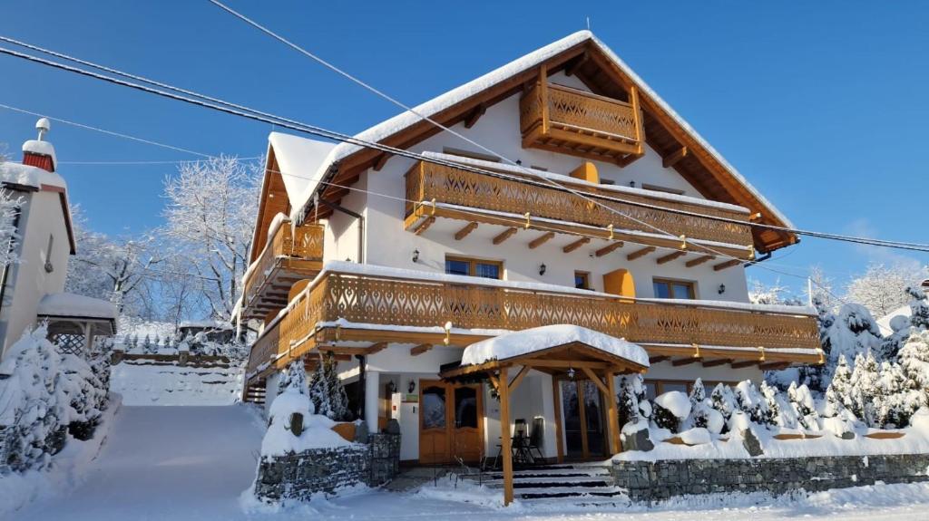 ein Haus im Schnee mit Schnee in der Unterkunft Rezydencja Nad Potoczkiem in Wisła