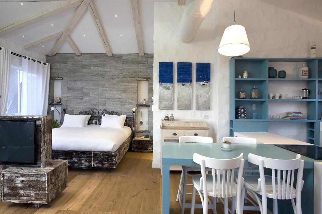 a bedroom with a bed and a table and chairs at Molcho Neve Tzedek in Tel Aviv