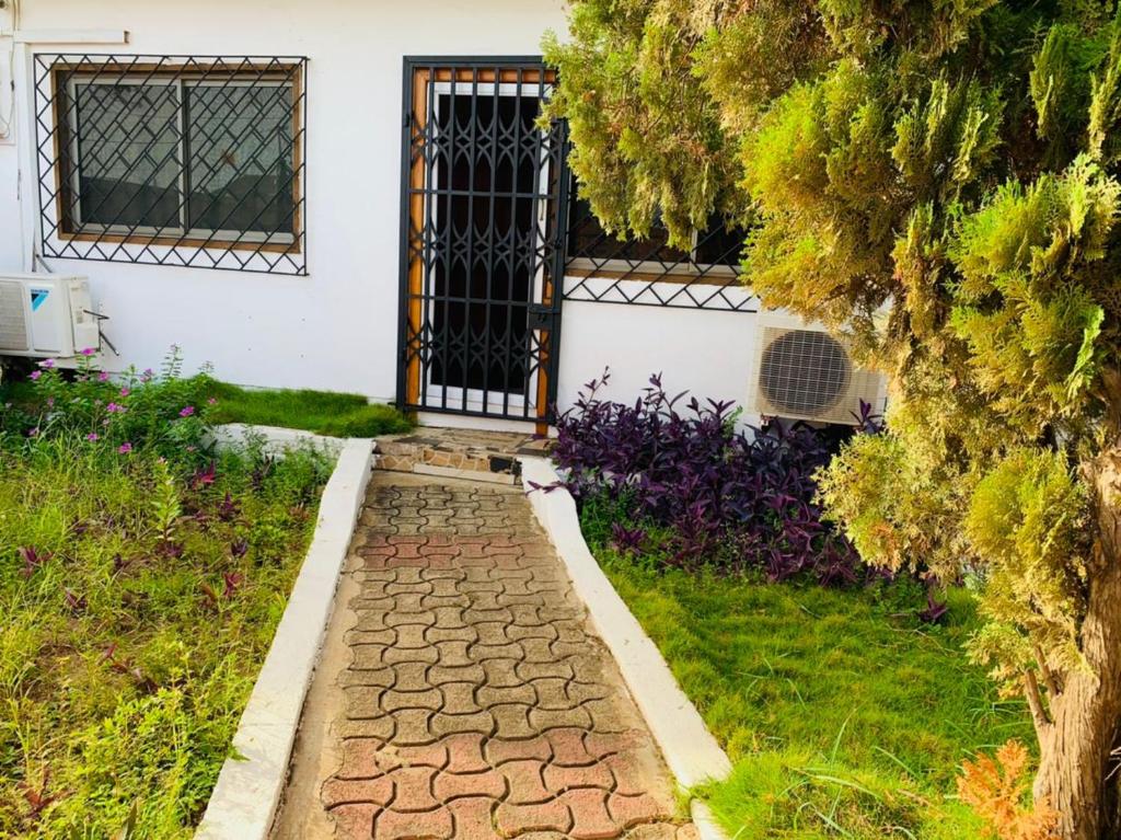 a walkway in front of a house with a gate at Stunning 1-Bed House in Tema- Oheneba villa in Tema