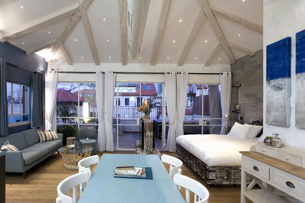 a bedroom with a bed and a couch and a table at Molcho Neve Tzedek in Tel Aviv