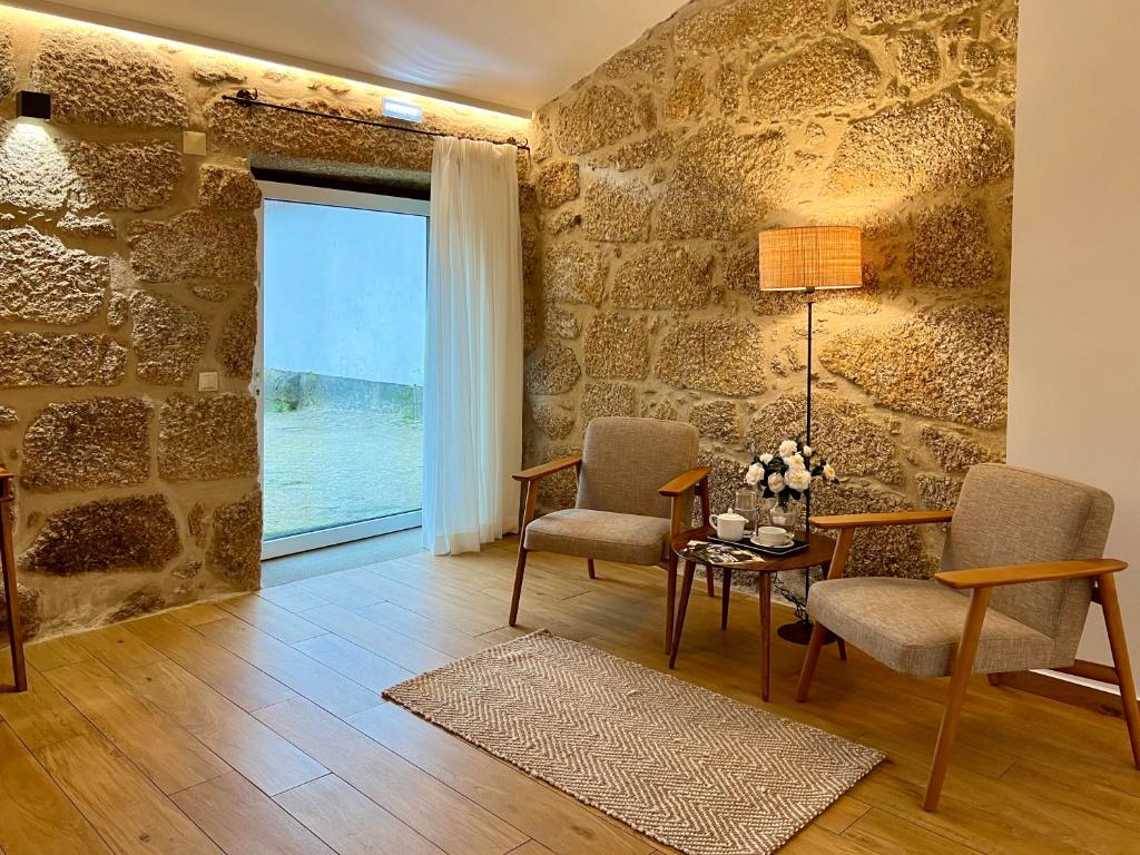 een woonkamer met 2 stoelen en een tafel bij Quinta da Porta - Solar de Vale de Prazeres in Vale de Prazeres