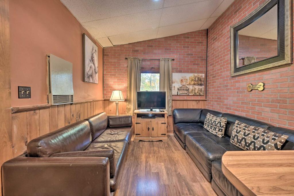 a living room with a leather couch and a tv at Bill Pickett Apt on 50-Acre Ranch - 1 Mi to Lake in Huntingdon