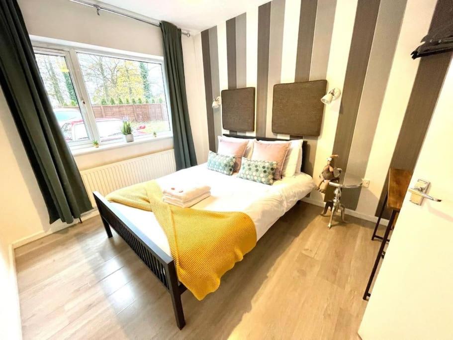 a bedroom with a bed with a yellow blanket on it at Serene and Cozy 1-Bedroom House with Parking in Cambridge