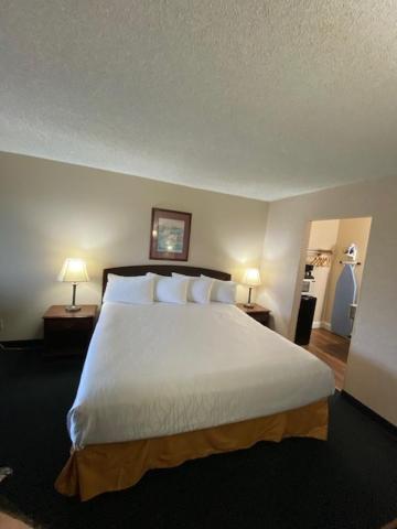 a bedroom with a large white bed with two lamps at AmeriCoast Inn in Brookings