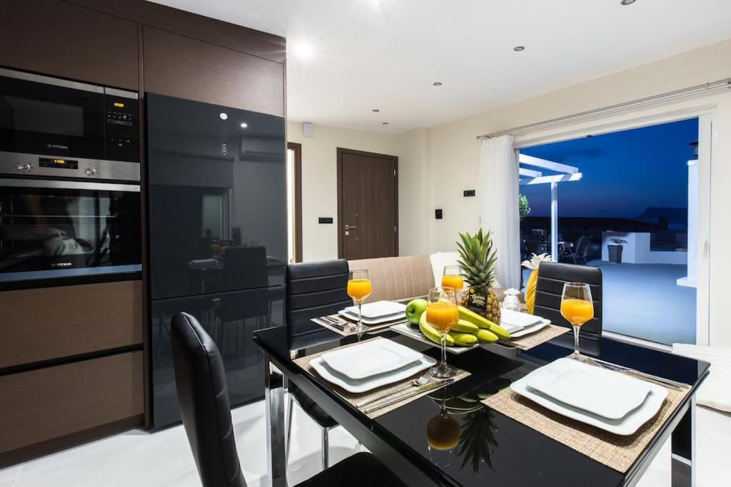 uma cozinha e sala de jantar com uma mesa com copos de vinho em Home Sweet Home - Big Balcony with Great View em Kissamos