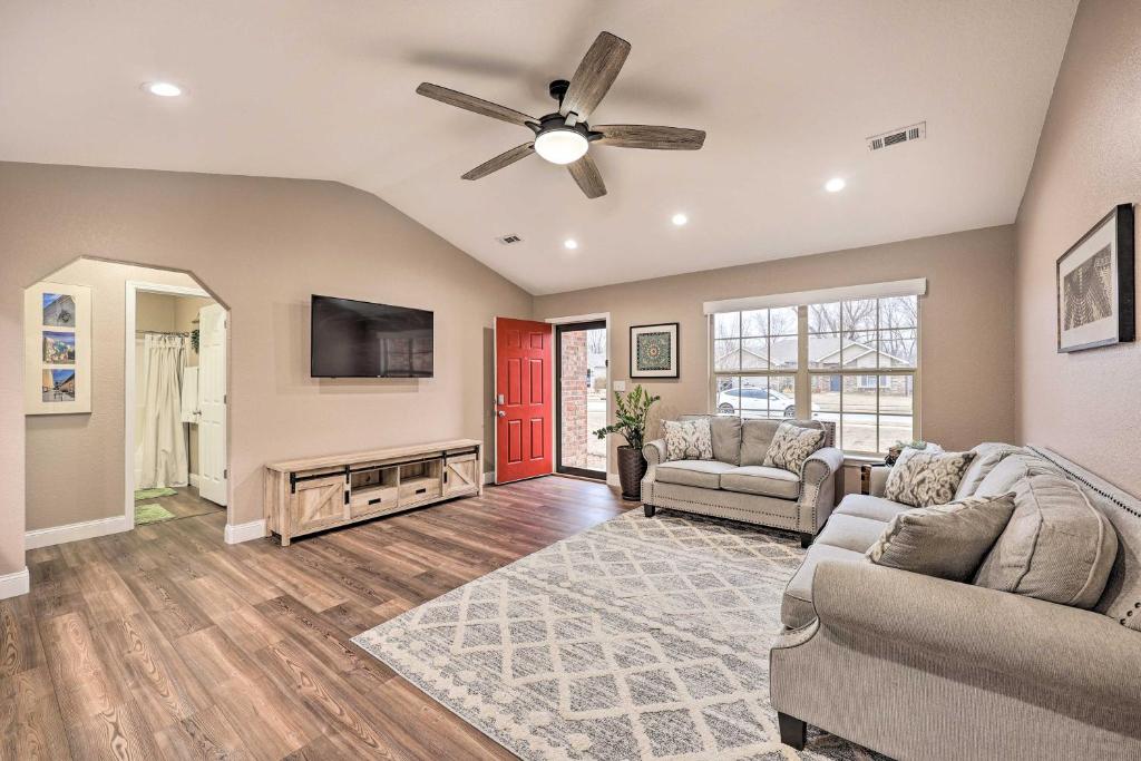 a living room with two couches and a ceiling fan at Gorgeous Bentonville Vacation Rental! in Bentonville