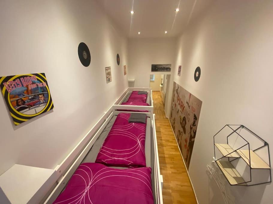een rij paarse bedden in een kamer bij Cozy appartm with + airport/city center connection in Wenen
