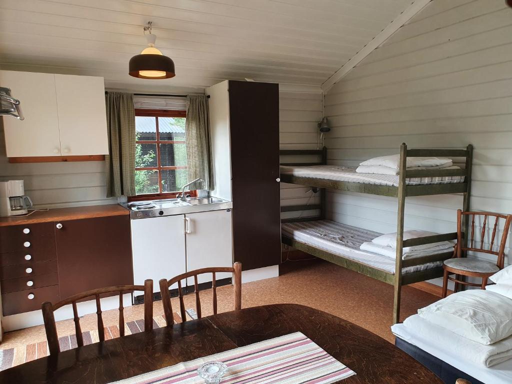 um quarto com 2 beliches e uma mesa em Lufta Camping & Restaurang em Ånäset