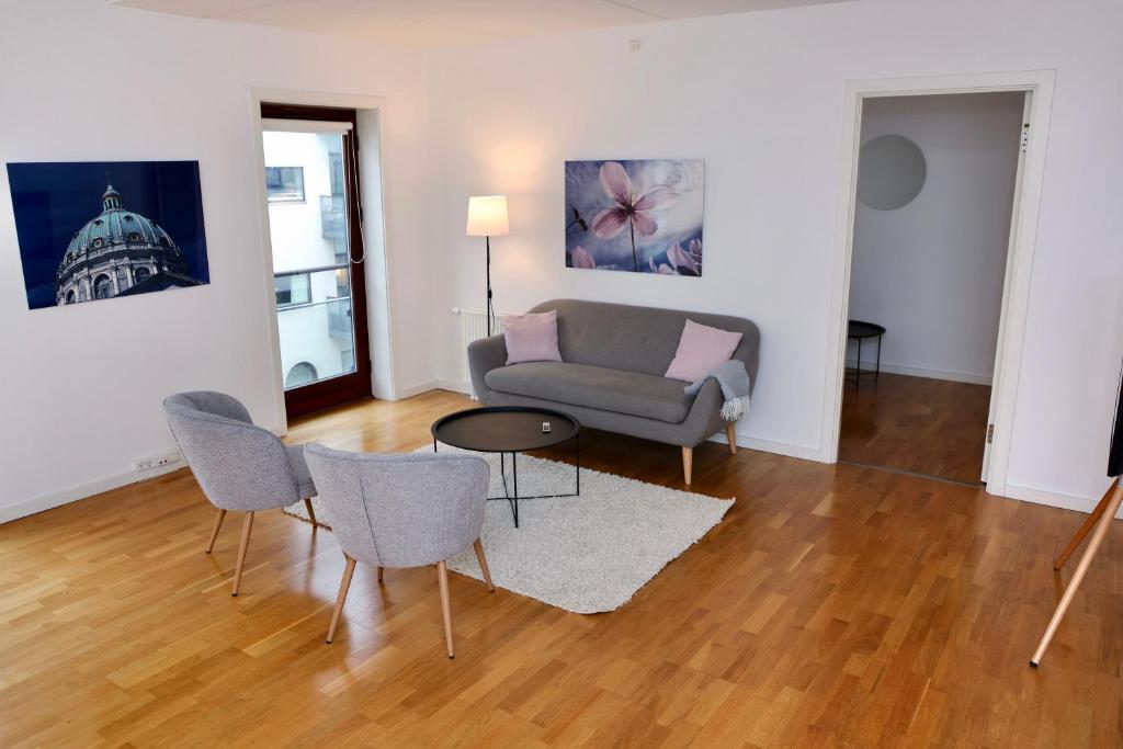 a living room with a couch and a table and chairs at Scandi-Hygge 2 bedroom apartment in charming Christianshavn in Copenhagen