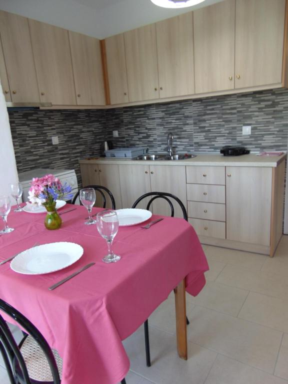 a kitchen with a table with a pink table cloth at Villa Avra in Dassia