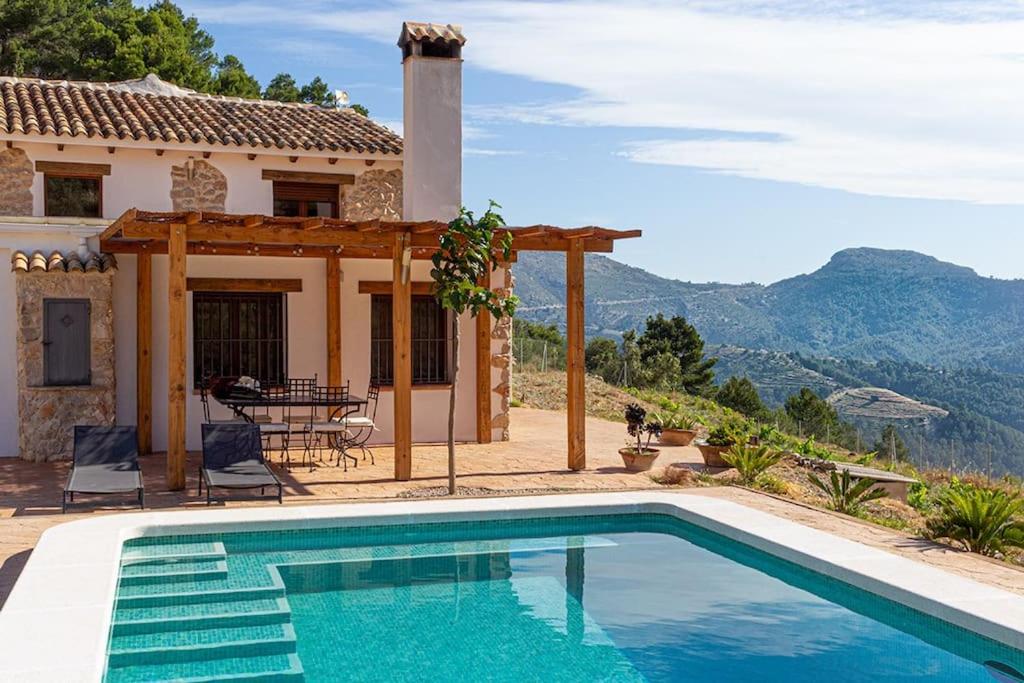 Villa con piscina frente a una casa en Rural ca´s Pelut, en Tàrbena