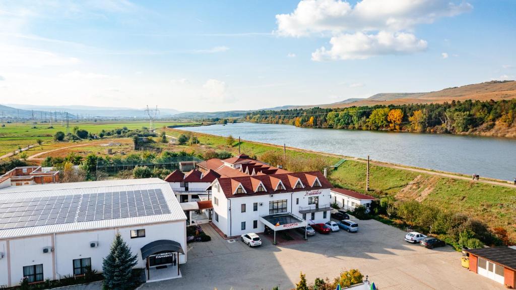 an aerial view of a large house with a river at Pensiunea Casa Zanelor in Floreşti