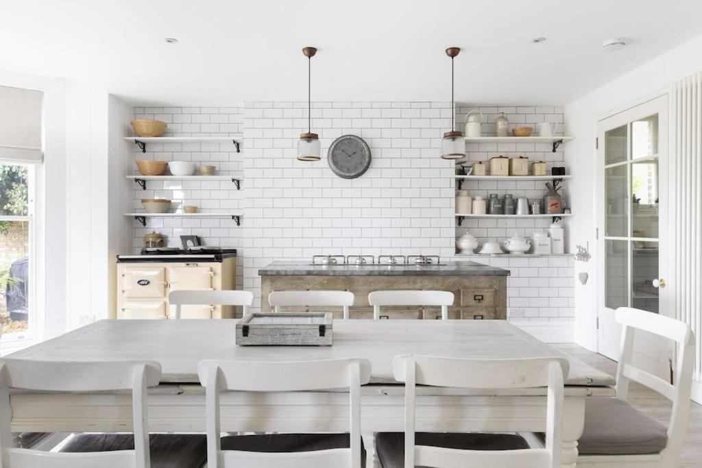 uma cozinha branca com mesa e cadeiras em High View Large Luxury House em Norwood