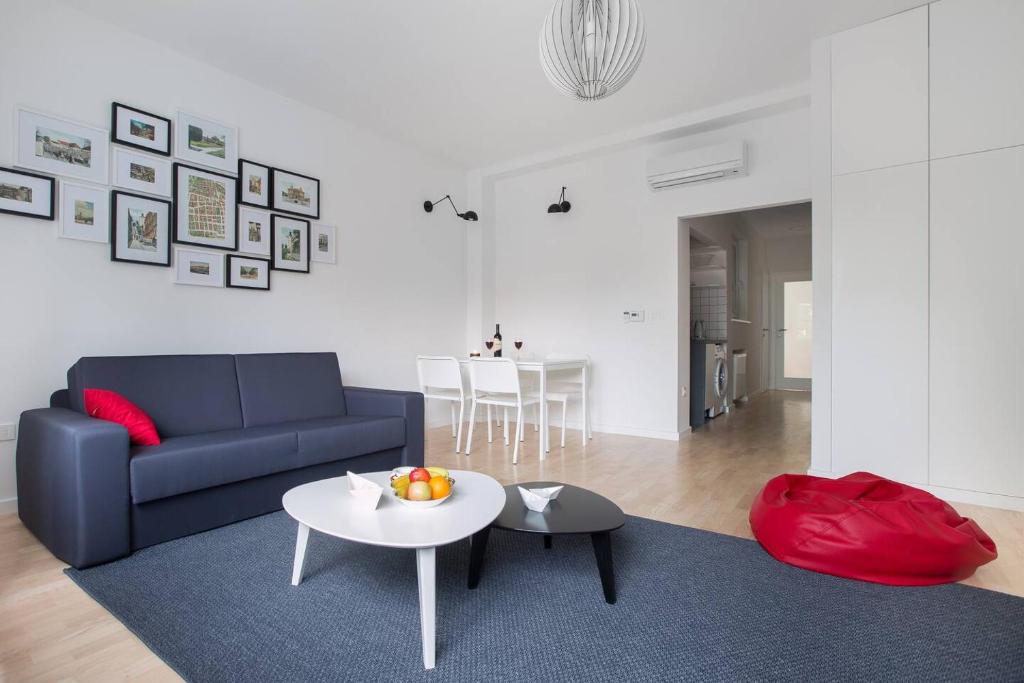 ein Wohnzimmer mit einem blauen Sofa und einem Tisch in der Unterkunft 4gZg Apartment in Zagreb