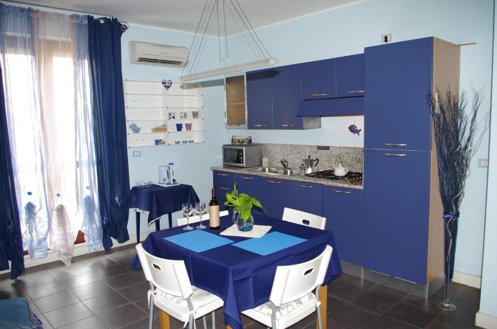 a kitchen with blue cabinets and a blue table and chairs at Casa Del Mar in Alghero