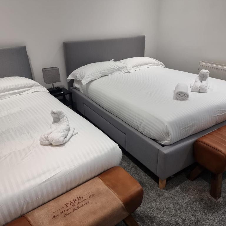 two beds with stuffed animals on them in a bedroom at Prescot Rooms in Liverpool