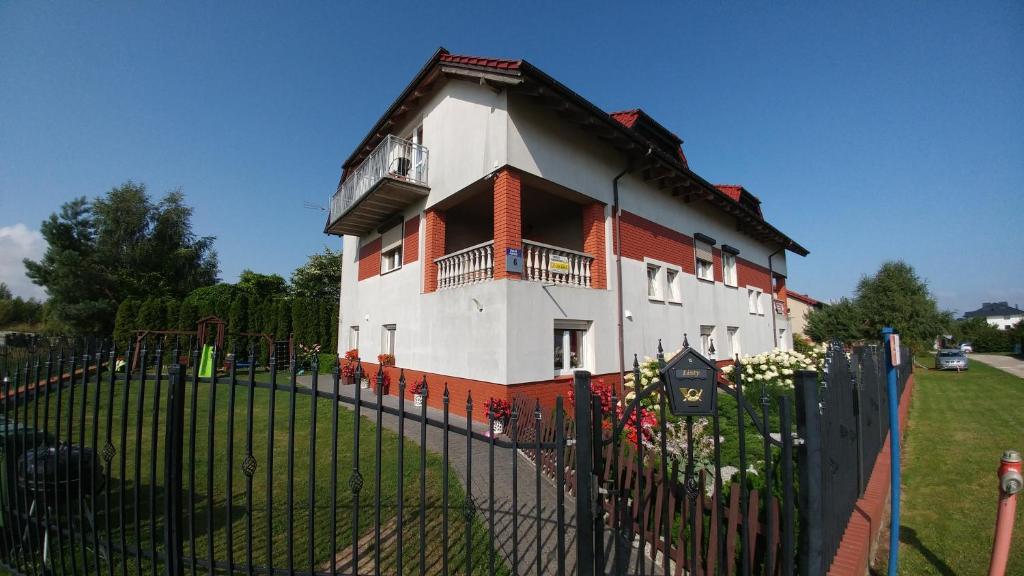 a building with a fence in front of it at U BLIŹNIAKÓW pokoje gościnne in Gąski