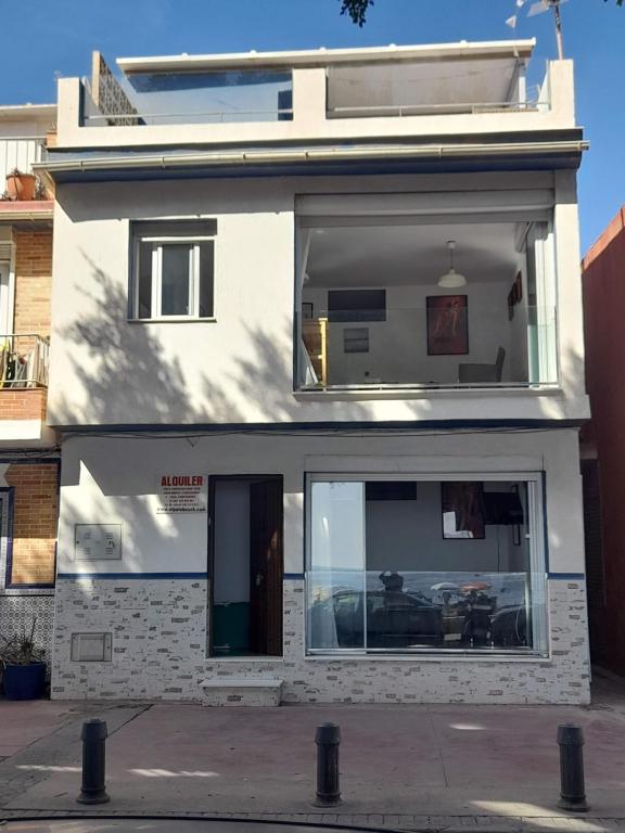 ein weißes Gebäude mit einem großen Fenster darauf in der Unterkunft Beachfront House in Málaga