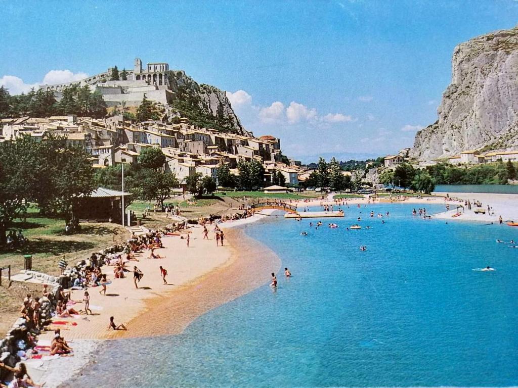 Ein Strand mit einem Haufen Leute im Wasser. in der Unterkunft Gîte de charme le val Mellis classé 3 étoiles dans la douceur provençale in Vaumeilh