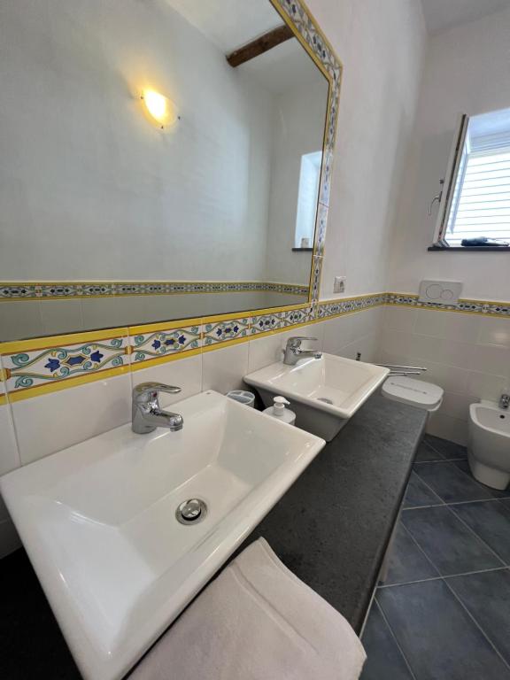 a bathroom with a white sink and a mirror at Lo Nardo Accommodation in Lipari