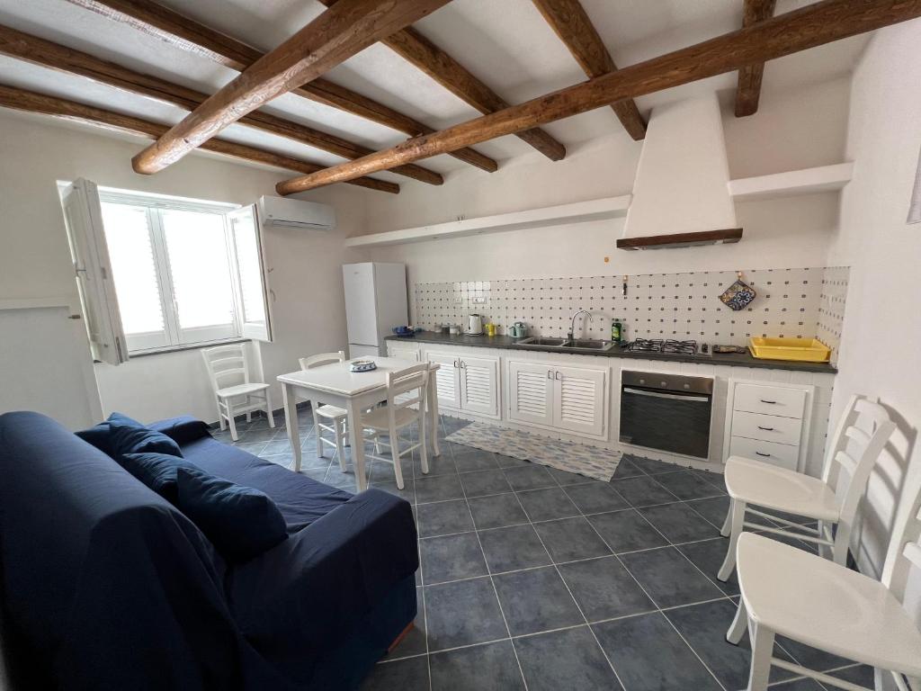 a living room with a blue couch and a kitchen at Lo Nardo Accommodation in Lipari